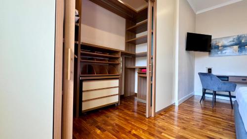 a bedroom with a closet with a desk and a chair at La Fontana Luxury Apartment in Nettuno