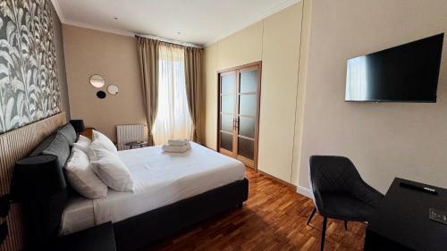 a hotel room with a bed and a flat screen tv at La Fontana Luxury Apartment in Nettuno