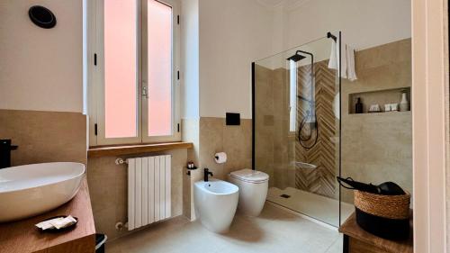 a bathroom with a sink and a toilet and a shower at La Fontana Luxury Apartment in Nettuno