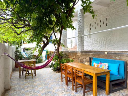 a patio with a hammock and a table and chairs at Vito Hotel Boutique Taganga in Taganga