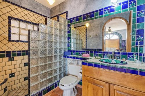 ein Badezimmer mit Toilette, Waschbecken und Spiegel in der Unterkunft Vistas de Las Olas West Suite in Puerto Peñasco