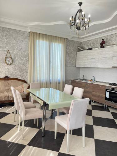 a kitchen and dining room with a table and chairs at Riverside Cottage Poti in Poti