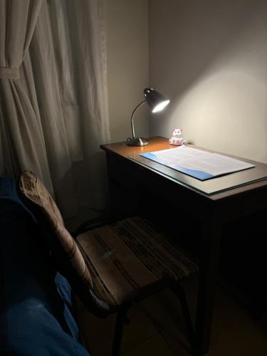 a desk with a lamp and a table with a chair at Casona tupuraya in Cochabamba