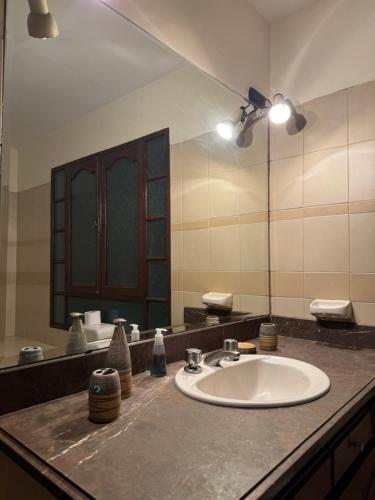 a bathroom with a sink and a large mirror at Casona tupuraya in Cochabamba