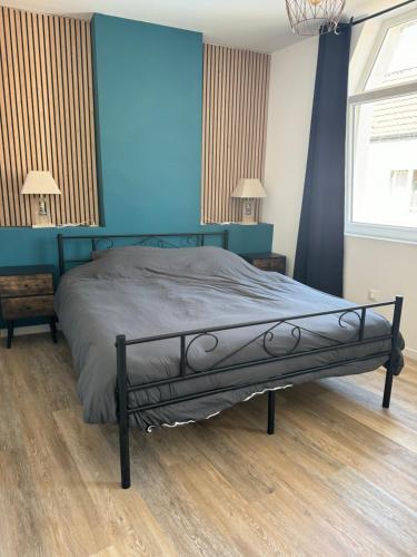 une chambre avec un lit avec un mur bleu dans l'établissement Gîte gina, à Grand-Fort-Philippe