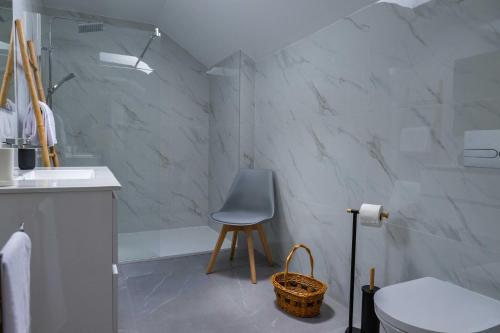 a bathroom with a chair and a sink and a toilet at Vó Laide in Carvalhal da Loiça