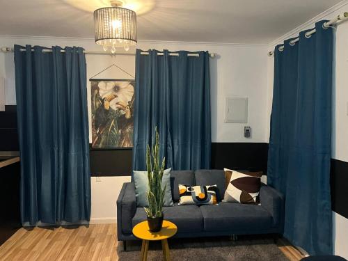 a living room with blue curtains and a couch at 4BlessingsCuracao1 in Willemstad