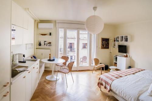 a bedroom with a bed and a table and a kitchen at Pannonia View Delight in Budapest