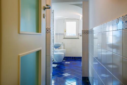 uma casa de banho com 2 WC e piso em azulejo azul em Le Case Di Rosella em Vico Equense