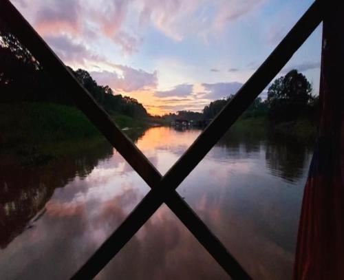 a view from a window of a river at sunset at Cabaña Flotante Kurupira in Leticia