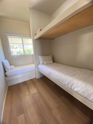 a bedroom with two bunk beds and a window at Lorsens on the River - Shoalhaven Heads in Shoalhaven Heads