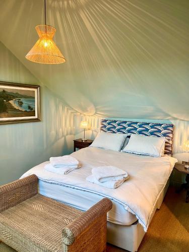 a bedroom with a large bed with a chandelier at The Pool House in Henley on Thames