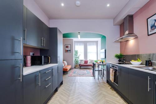 a kitchen with purple cabinets and a dining room at Modern 4-Bedroom in Manchester in Manchester