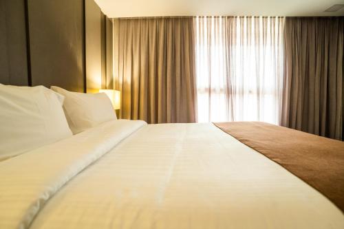 a large white bed in a hotel room with a window at Oceana Atlântico Hotel & SPA in João Pessoa
