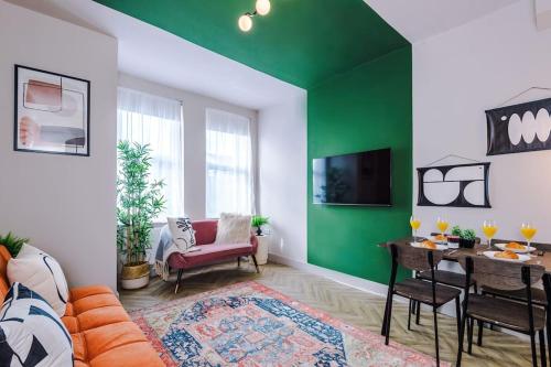 a living room with a green accent wall at Modern 4-Bedroom in Manchester in Manchester