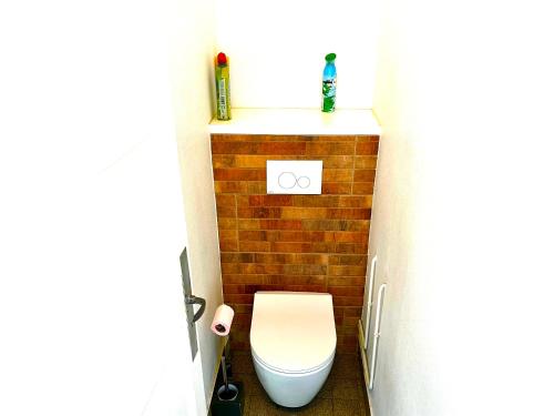 a bathroom with a toilet and a brick wall at Villa Cantarela, Palavas plage, Vue mer in Palavas-les-Flots