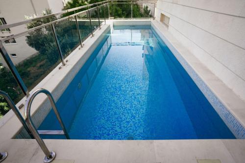 a swimming pool with blue water in a building at Montehome in Becici
