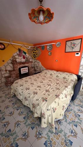 a bed in a bedroom with an orange wall at B&B Mamma Mia s in Airola