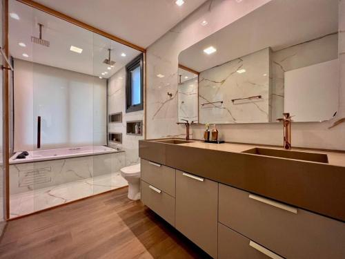 un bagno con lavandino, WC e vasca di Luxo e Exclusividade no Ilhas Resort a Capão da Canoa