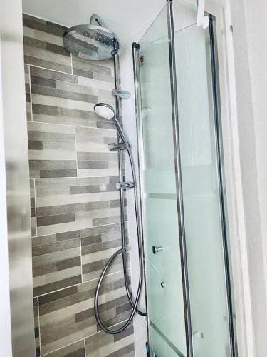 une douche avec une porte vitrée dans une salle de bain dans l'établissement Bel appartement pour un séjour touristique, à Paris