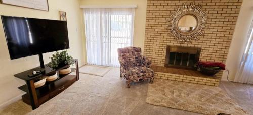 a living room with a fireplace and a chair and a television at Hot Air Balloon Haven, Hot Tub, King Bed, Office, Foosball, Bball in Albuquerque