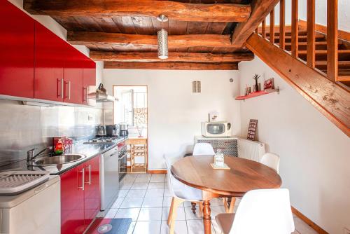 une cuisine avec des placards rouges et une table en bois dans l'établissement Maison de campagne au cœur de l'Auxois - Tivauche-le-Haut en Côte d'Or, à Corsaint