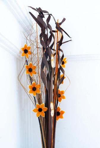 a vase filled with orange flowers in a room at Rainbow Heights Apartment, Soufriere in Soufrière