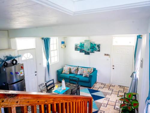 a living room with a blue couch and a table at Rainbow Heights Apartment, Soufriere in Soufrière