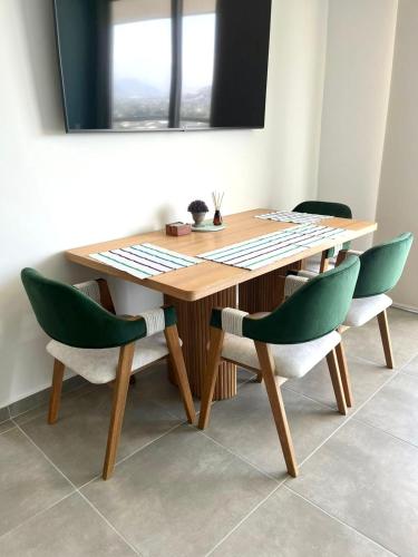 a wooden table with two green chairs and a mirror at Salguero Suites - Playa Salguero - By INMOBILIARIA VS in Santa Marta