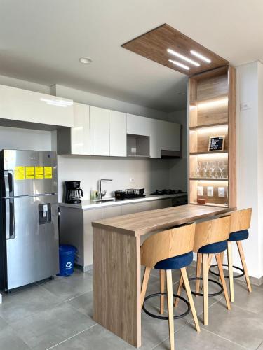 a kitchen with a wooden table and some chairs at Salguero Suites - Playa Salguero - By INMOBILIARIA VS in Santa Marta