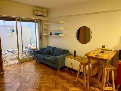 Una sala de estar con un sofá azul y una mesa. en Cozy apartment in the heart of San Telmo, en Buenos Aires