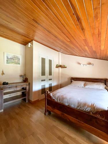 une chambre avec un lit et un plafond en bois dans l'établissement Appartement 2 chambres avec terrasse, à Polliat