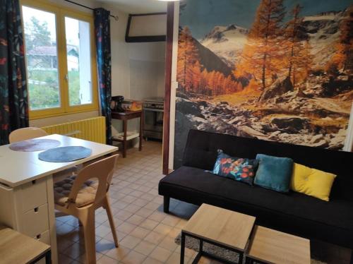 a living room with a couch and a table at Appartement 2 chambres avec terrasse in Polliat
