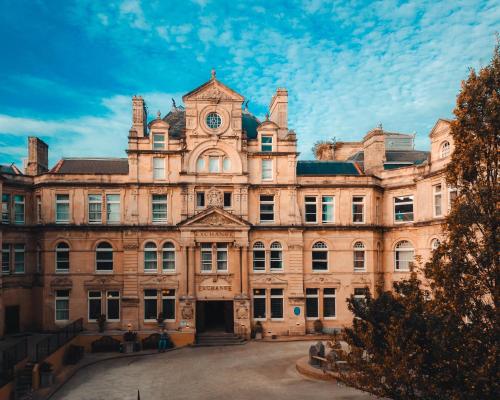 an old building with a clock on the front at The Coal Exchange Hotel in Cardiff