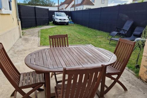 une table en bois avec quatre chaises et une clôture dans l'établissement Dolce vita, à Amnéville