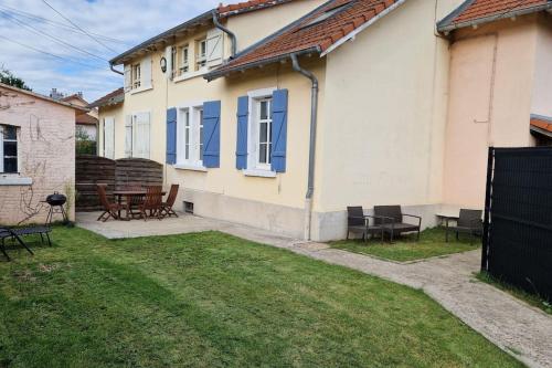 une maison avec des fenêtres bleues et une table de pique-nique dans une cour dans l'établissement Dolce vita, à Amnéville
