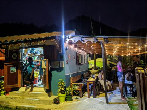 a group of people sitting outside of a food truck at Rainbow Heights Apartment, Soufriere in Soufrière
