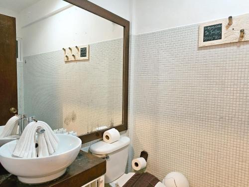 a bathroom with a sink and a toilet and a mirror at 40 Cañones in Mahahual