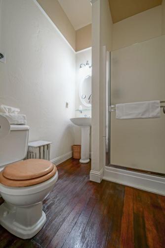 a bathroom with a toilet with a shower and a sink at Weaverville Hotel in Weaverville