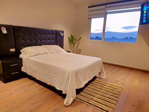 a bedroom with a large bed and a window at Comodo y equipado departamento en la Av Juan de la Rosa in Calacala
