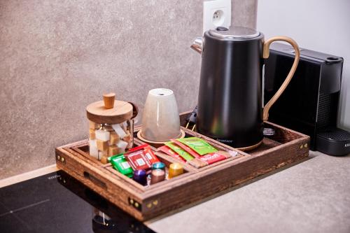 a wooden tray with food items and a kettle on a counter at Urban Chic Apartment in the Heart of Mechelen in Mechelen