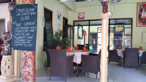 a restaurant with a table with chairs and a chalkboard at Ayu Taman Sari in Candidasa
