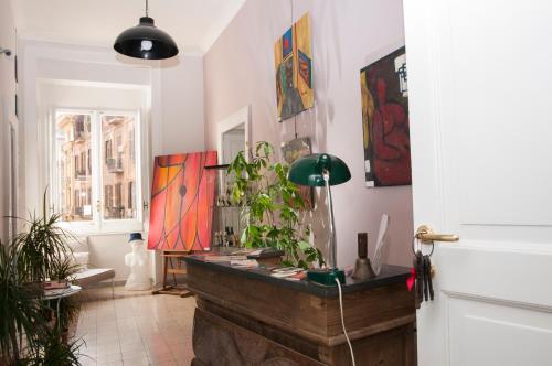 una habitación con una mesa con plantas y pinturas en Napul'art, en Nápoles