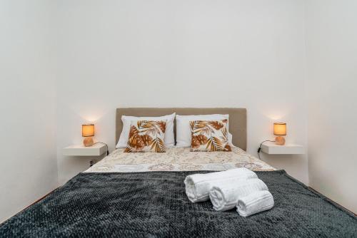 a bedroom with a bed with two towels on it at Atouguia House - Traditional House in Calheta