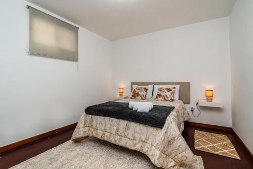 a bedroom with a bed and a flat screen tv at Atouguia House - Traditional House in Calheta