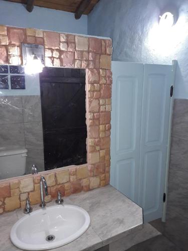 a bathroom with a sink and a stone wall at Casa de campo parque Iberá in Colonia Carlos Pellegrini