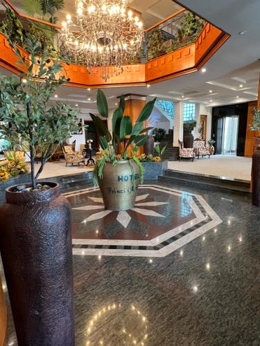 a lobby with a large potted plant and a chandelier at Hotel Princi i Arberit in Pristina