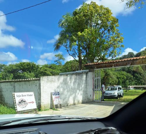 a car parked next to a building with a tree at Rancho Ohana in Peruíbe