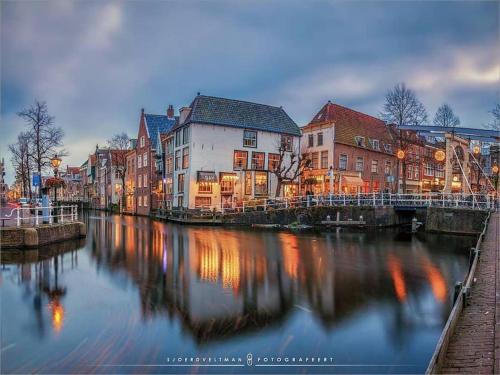 a city with a river with buildings and a bridge at Hoogwaardig afgewerkt loft in oude stadscentrum in Alkmaar