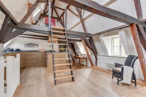 a kitchen with a spiral staircase in a loft at Hoogwaardig afgewerkt loft in oude stadscentrum in Alkmaar